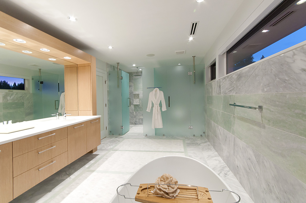 Master ensuite with marble walls, soaking tub, and walk-through glass shower