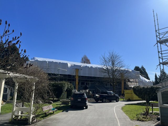20-unit North Vancouver building tented in shrink-wrap weather containment during roof tear-off